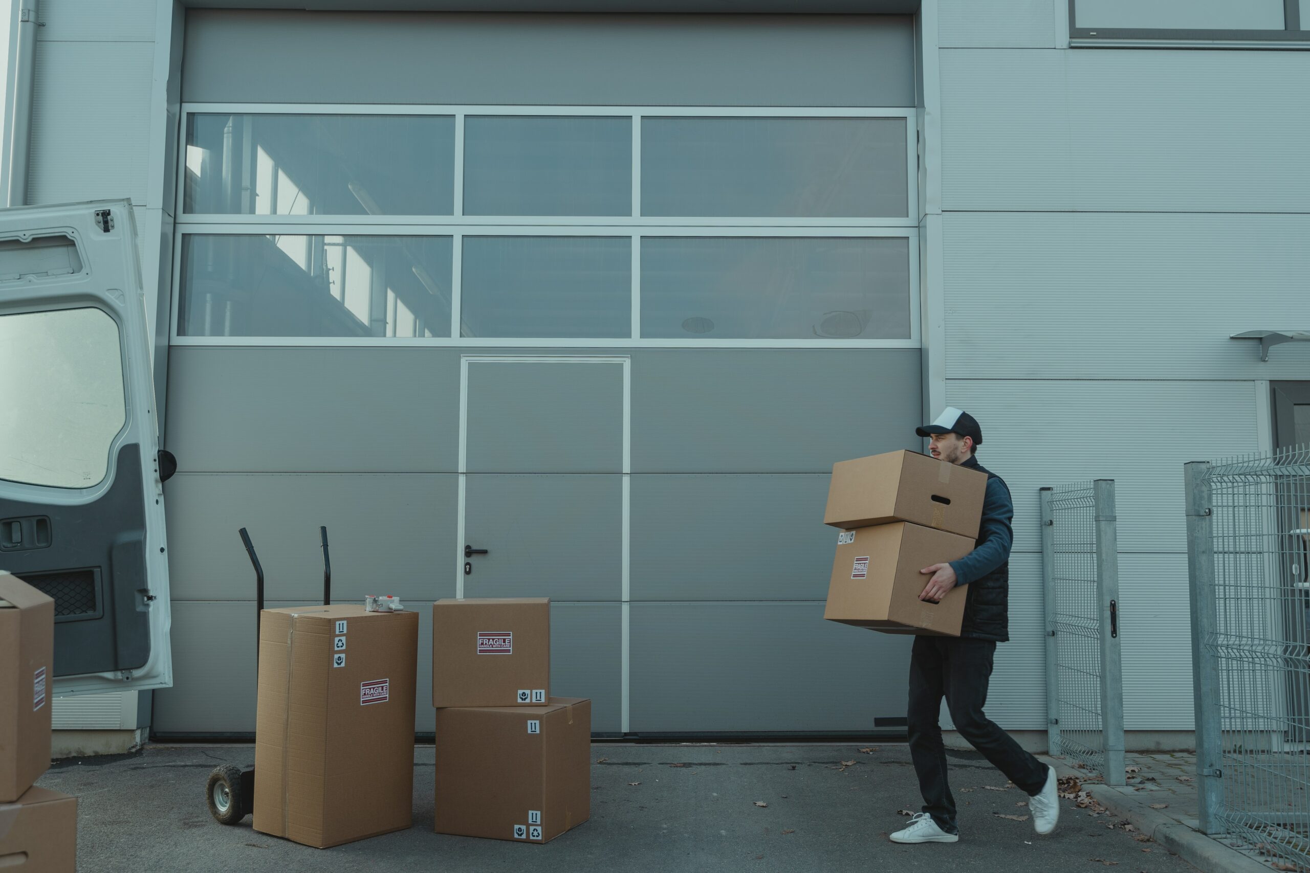 une personne qui charge des cartons dans un camion pour des déménagements groupés