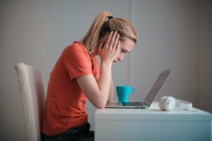 Une femme ayant une migraine devant son PC