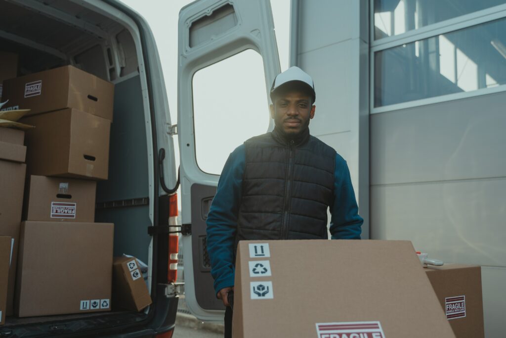 Une personne qui transporte des cartons pour des déménagements groupés