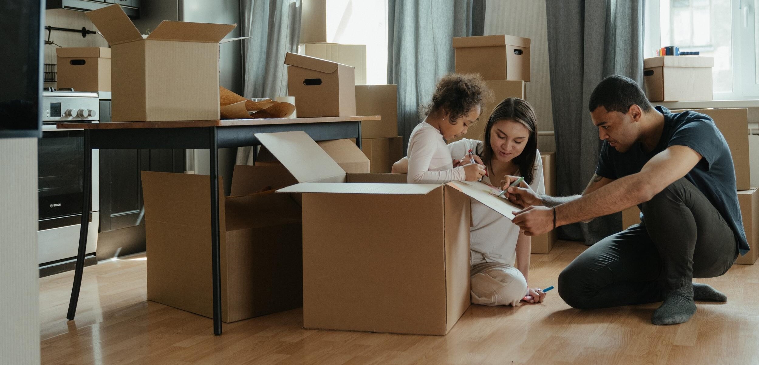 Les membres d'une famille emballant leurs affaires pour limiter les coûts d'un déménagement