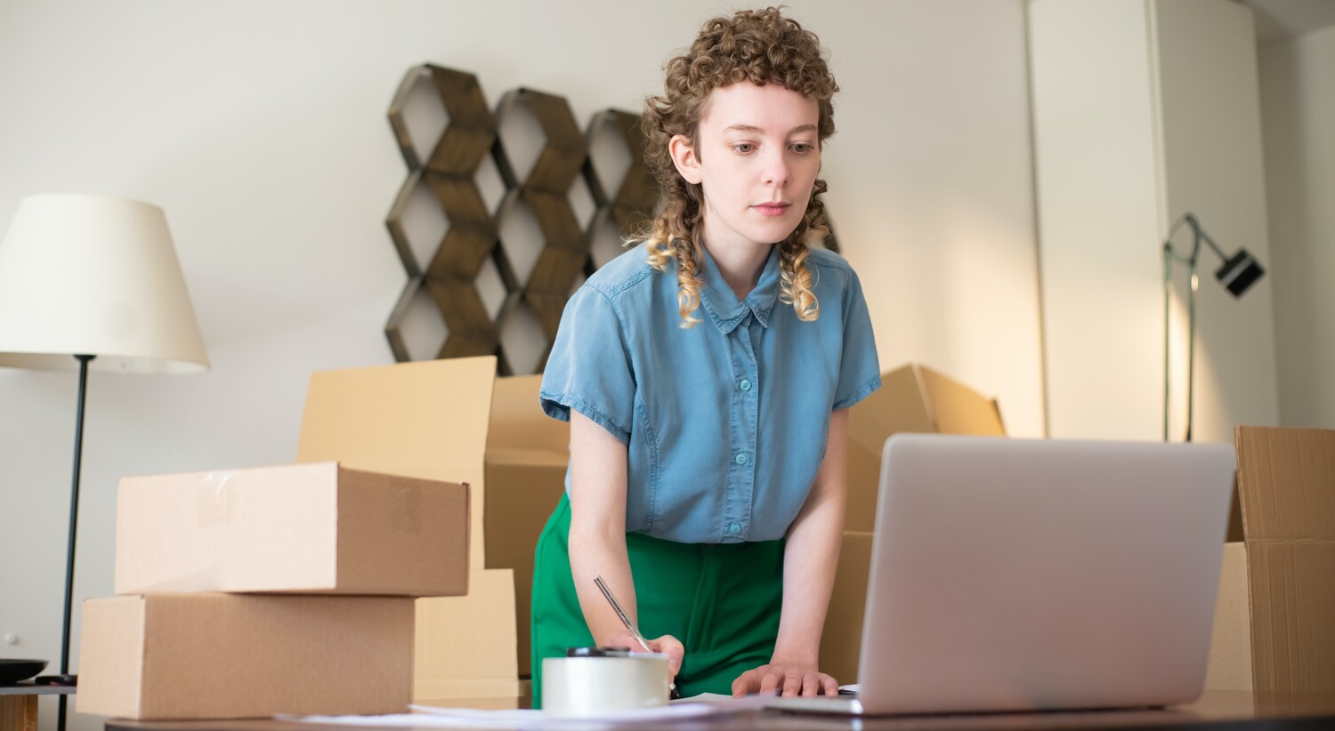 Devis déménagement : une femme sur son bureau devant un amas de cartons